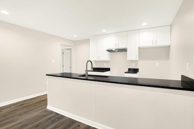 3374 Given Ave, Memphis, TN 38122 - kitchen featuring under cabinet range hood, white cabinets, dark wood finished floors, recessed lighting, and a peninsula