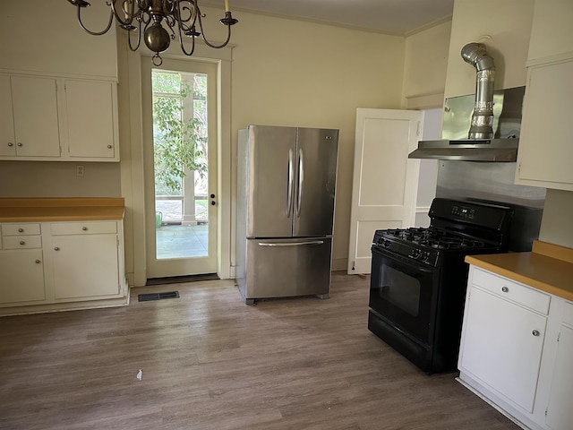 4042 Goodlett Cv, Memphis, TN 38111 - kitchen featuring freestanding refrigerator, gas stove, a chandelier, white cabinets, and wood finished floors