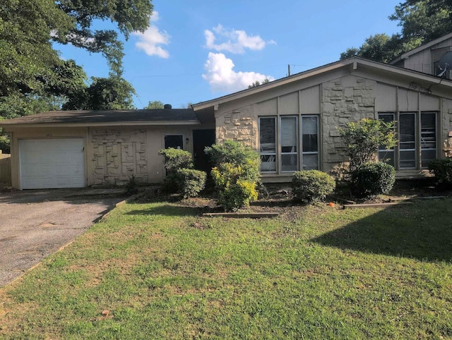 4915 Foxhall Cv, Memphis, TN 38118 - view of front of house featuring an attached garage, a front lawn, stone siding, and concrete driveway