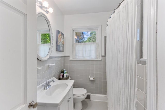 4670 Kaye Rd, Memphis, TN 38117 - full bathroom with vanity, healthy amount of natural light, tile walls, a shower with shower curtain, and wainscoting