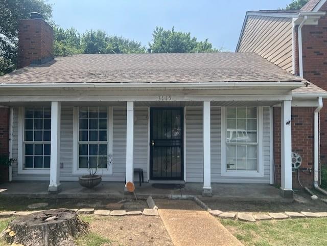 3115 S Wesley Ct, Memphis, TN 38119 - view of exterior entry featuring a porch, brick siding, a shingled roof, and a chimney