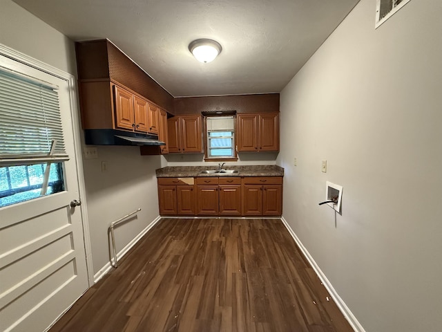 4592 Neely Rd, Memphis, TN 38109 - kitchen featuring dark wood-style floors, under cabinet range hood, dark countertops, and brown cabinets
