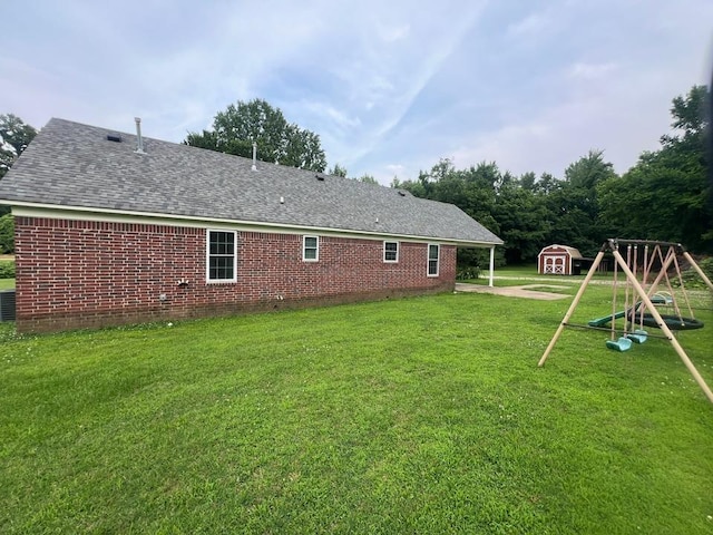 199 Bucksnort Rd, Covington, TN 38019 - back of property featuring a shed, a yard, roof with shingles, and brick siding