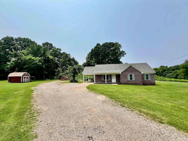199 Bucksnort Rd, Covington, TN 38019 - single story home with dirt driveway, a storage unit, a front lawn, and brick siding