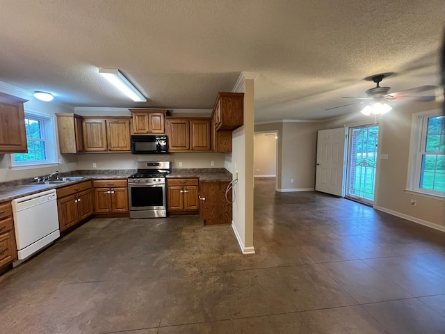 199 Bucksnort Rd, Covington, TN 38019 - kitchen featuring black microwave, dishwasher, stainless steel gas range oven, brown cabinetry, and a textured ceiling