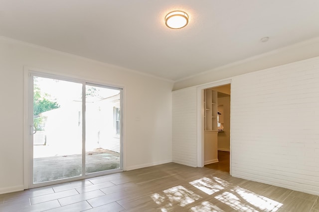 4143 Hilldale Ave, Memphis, TN 38117 - unfurnished room with crown molding, brick wall, and light wood-type flooring