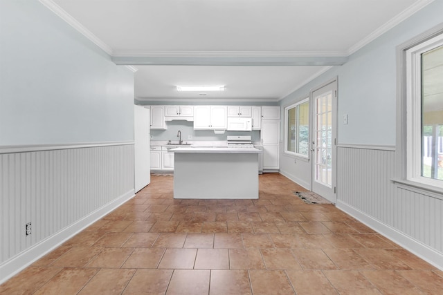3024 Keats Rd, Bartlett, TN 38134 - kitchen featuring white microwave, white cabinets, a wainscoted wall, light countertops, and a kitchen island