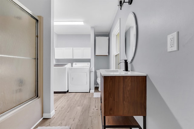 3024 Keats Rd, Bartlett, TN 38134 - full bathroom with vanity, independent washer and dryer, wood finished floors, and shower / bath combination with glass door