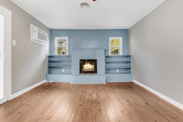 3024 Keats Rd, Bartlett, TN 38134 - unfurnished living room featuring a brick fireplace, hardwood / wood-style flooring, ornamental molding, a wall unit AC, and a ceiling fan