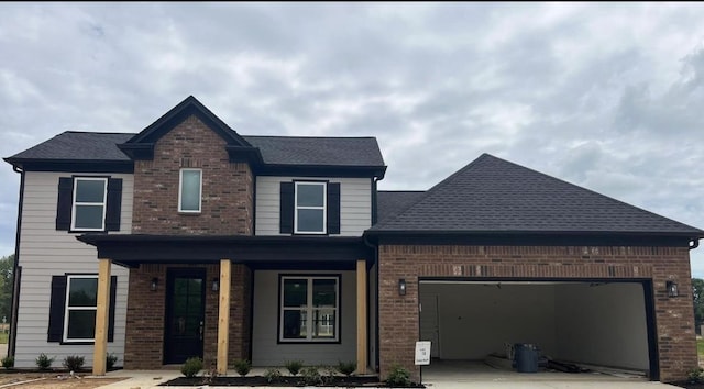 10289 March Meadows Way, Olive Branch, MS 38654 - view of front facade featuring brick siding, a garage, covered porch, concrete driveway, and roof with shingles