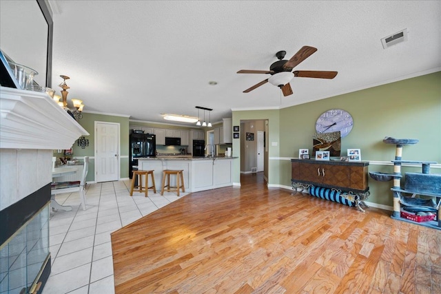 6806 Briarfield Ln, Bartlett, TN 38135 - living room featuring crown molding, ceiling fan, light tile patterned floors, a textured ceiling, and a chandelier