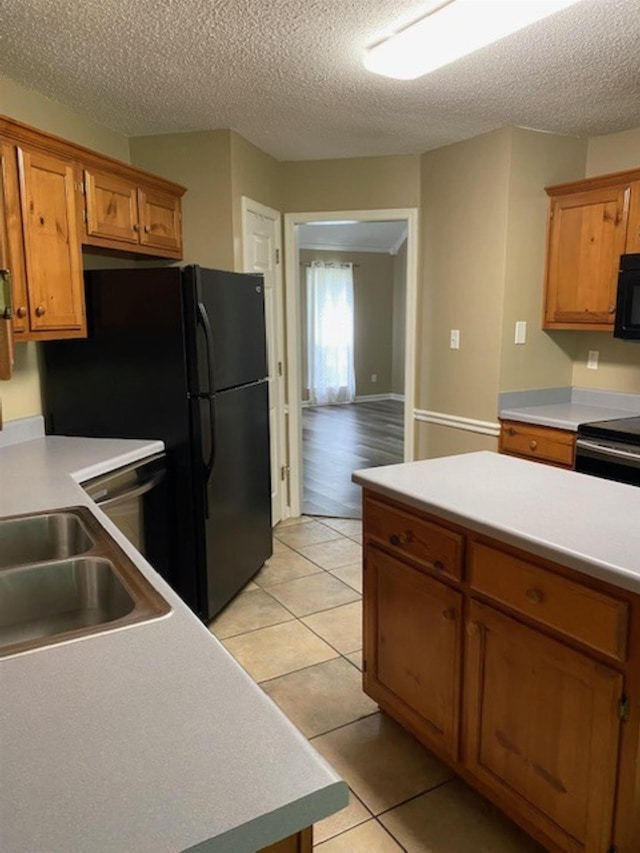 4769 Shadow View Ln, Bartlett, TN 38002 - kitchen featuring black appliances, brown cabinetry, light tile patterned floors, a textured ceiling, and light countertops