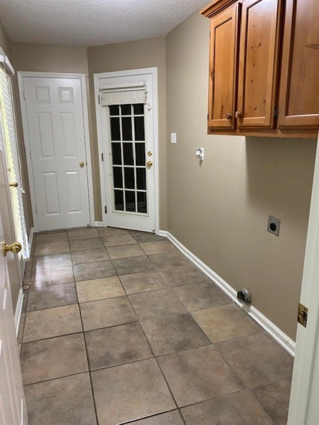 4769 Shadow View Ln, Bartlett, TN 38002 - laundry area with electric dryer hookup, cabinet space, a textured ceiling, and tile patterned floors
