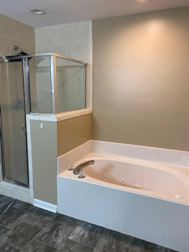 4769 Shadow View Ln, Bartlett, TN 38002 - bathroom featuring a textured ceiling, a jetted tub, and a shower stall