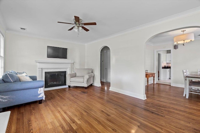 193 Alexander St, Memphis, TN 38111 - living area featuring arched walkways, a ceiling fan, wood finished floors, ornamental molding, and a brick fireplace