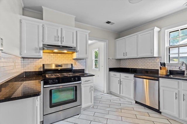 193 Alexander St, Memphis, TN 38111 - kitchen with stainless steel appliances, under cabinet range hood, white cabinets, dark countertops, and crown molding