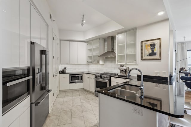 717 Riverside Dr Unit 1403, Memphis, TN 38103 - kitchen featuring wall chimney range hood, high end appliances, light marble finish flooring, backsplash, and a peninsula