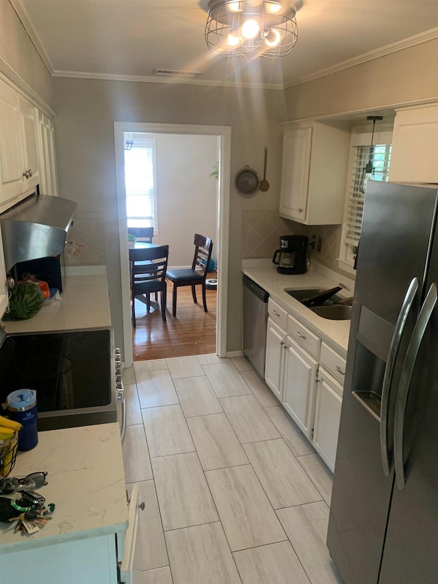 2526 Currywood Cv, Germantown, TN 38138 - kitchen featuring stainless steel appliances, crown molding, white cabinetry, tasteful backsplash, and a chandelier
