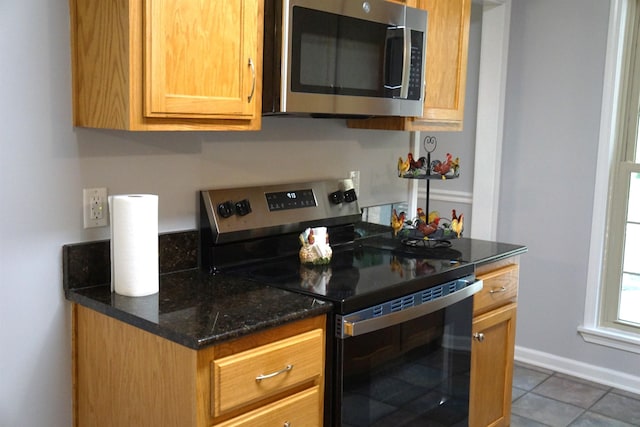 227 Lake Shore Dr, Munford, TN 38058 - kitchen with stainless steel appliances, tile patterned flooring, and dark stone counters