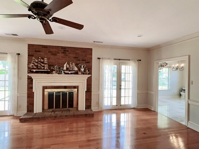 9168 Sycamore Creek Cv, Germantown, TN 38139 - unfurnished living room featuring wood finished floors, a glass covered fireplace, a ceiling fan, a chandelier, and ornamental molding