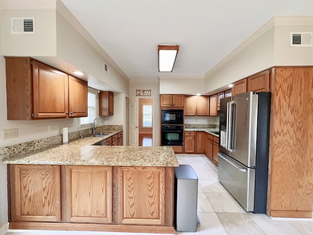 9168 Sycamore Creek Cv, Germantown, TN 38139 - kitchen featuring black appliances, a peninsula, crown molding, light stone counters, and brown cabinetry