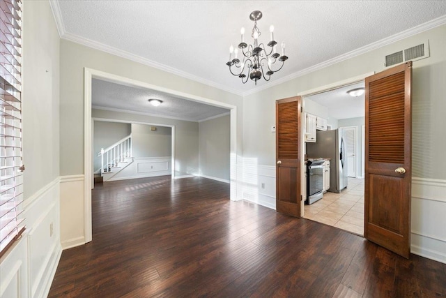 1425 Treehaven Cv, Memphis, TN 38016 - empty room featuring a chandelier, light wood-type flooring, a textured ceiling, a decorative wall, and stairway