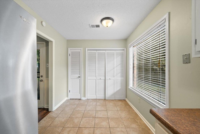 1425 Treehaven Cv, Memphis, TN 38016 - unfurnished bedroom featuring a closet, a textured ceiling, and light tile patterned flooring