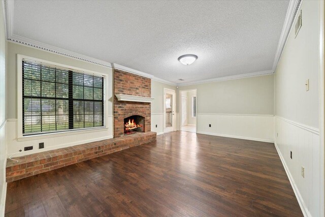 1425 Treehaven Cv, Memphis, TN 38016 - unfurnished living room with wood finished floors, a wainscoted wall, ornamental molding, a textured ceiling, and a fireplace