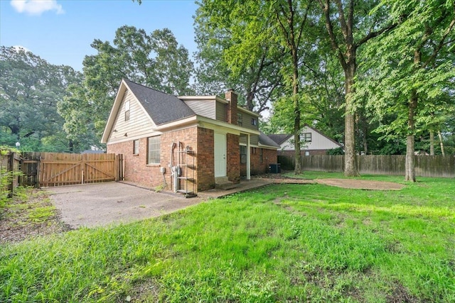 1425 Treehaven Cv, Memphis, TN 38016 - view of side of home with brick siding, a gate, a fenced backyard, and a chimney
