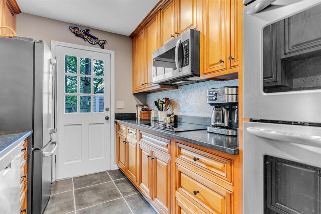2016 Restington Ln Unit 2016, Memphis, TN 38119 - kitchen with appliances with stainless steel finishes, decorative backsplash, dark tile patterned floors, and brown cabinets