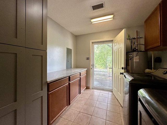 520 Jernigan Dr, Somerville, TN 38068 - laundry room with water heater, cabinet space, independent washer and dryer, light tile patterned flooring, and a textured ceiling