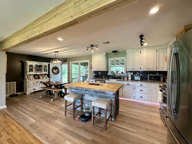 520 Jernigan Dr, Somerville, TN 38068 - kitchen featuring stainless steel appliances, white cabinetry, tasteful backsplash, light wood-type flooring, and butcher block countertops