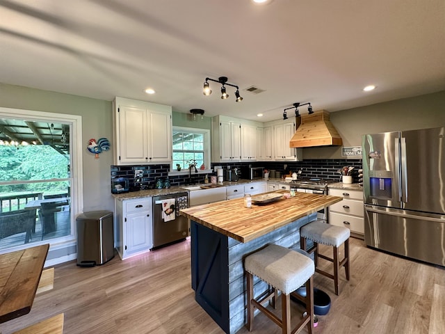 520 Jernigan Dr, Somerville, TN 38068 - kitchen with stainless steel appliances, custom range hood, wood counters, white cabinets, and light wood-style flooring