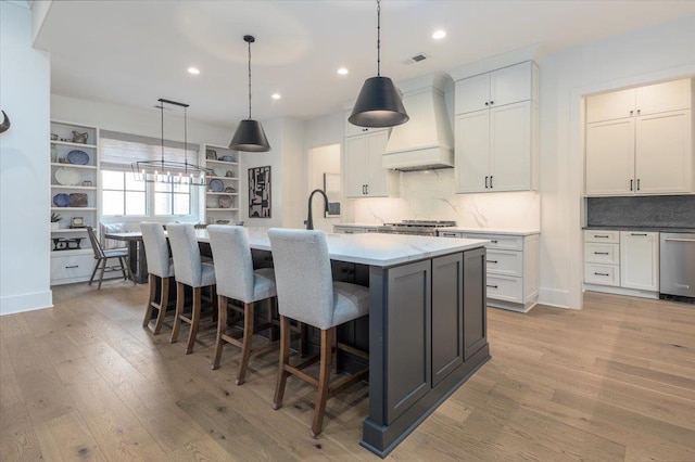 7066 Allelon Cir N, Germantown, TN 38138 - kitchen with custom exhaust hood, light wood-style flooring, dishwasher, decorative backsplash, and recessed lighting