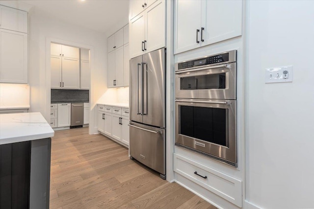 7066 Allelon Cir N, Germantown, TN 38138 - kitchen with stainless steel appliances, light wood finished floors, light stone countertops, and white cabinets