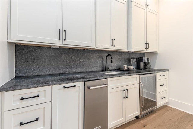 7066 Allelon Cir N, Germantown, TN 38138 - bar area with beverage cooler, light wood-style flooring, and backsplash