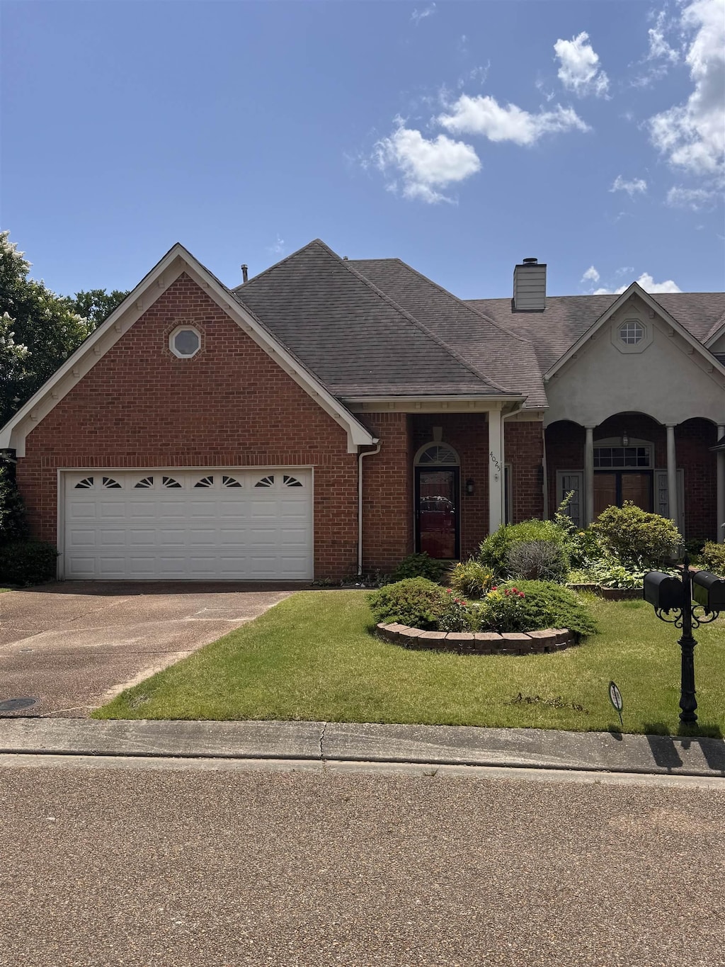 4025 Rolling Green Dr, Memphis, TN 38125 - view of front of home with brick siding, driveway, a front yard, and an attached garage