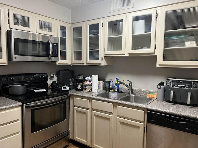 109 N Main St Unit 1202, Memphis, TN 38103 - kitchen with stainless steel appliances, glass insert cabinets, and light countertops