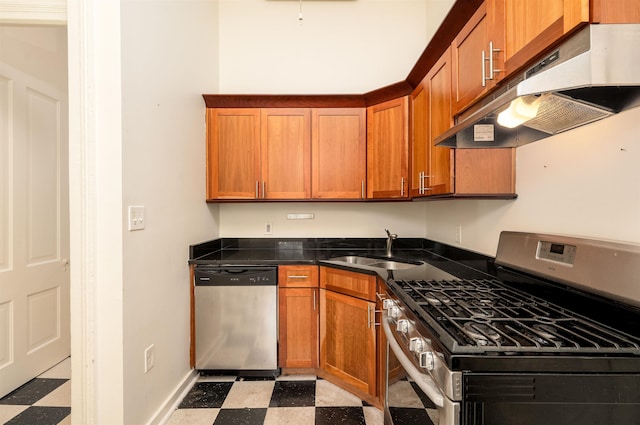 378 Mulberry St, Memphis, TN 38103 - kitchen with appliances with stainless steel finishes, under cabinet range hood, light flooring, and dark countertops