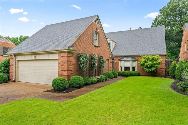 4654 Hemlock Ln, Memphis, TN 38117 - view of front facade with brick siding, roof with shingles, a front lawn, concrete driveway, and a garage