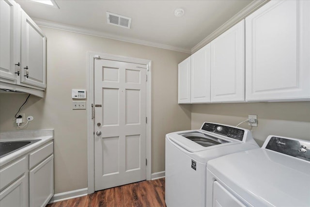 4654 Hemlock Ln, Memphis, TN 38117 - washroom with washing machine and clothes dryer, crown molding, dark wood-type flooring, and cabinet space