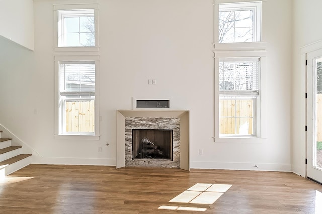 3615 Kearney Ave, Memphis, TN 38111 - unfurnished living room featuring a towering ceiling, wood finished floors, a high end fireplace, and stairway