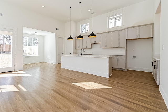3615 Kearney Ave, Memphis, TN 38111 - kitchen with a towering ceiling, a chandelier, an island with sink, healthy amount of natural light, and light wood-style flooring