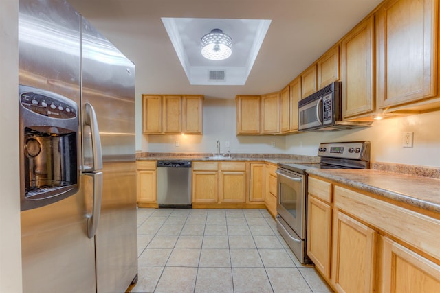 1841 Fernspring Cv Unit 26, Germantown, TN 38138 - kitchen featuring appliances with stainless steel finishes, a raised ceiling, light tile patterned flooring, light brown cabinets, and light countertops