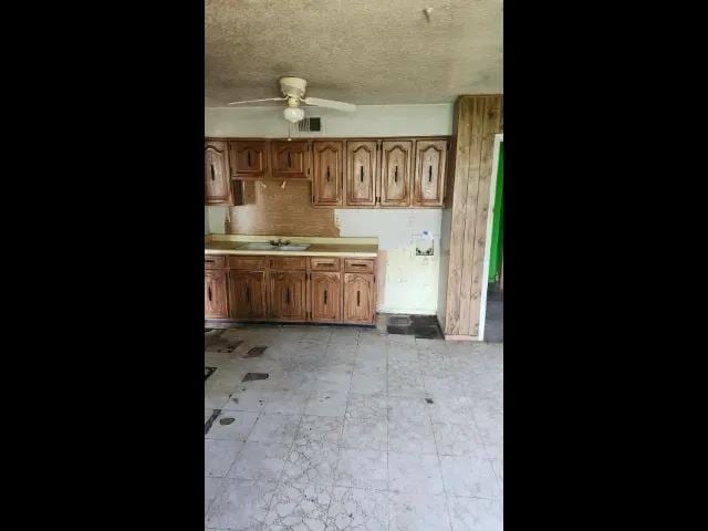 3394 Point Pleasant Ave, Memphis, TN 38118 - kitchen with ceiling fan, light countertops, a textured ceiling, and brown cabinets
