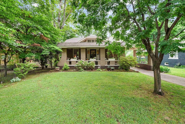 1668 Forest Ave, Memphis, TN 38112 - view of front facade featuring a porch, a front yard, and brick siding