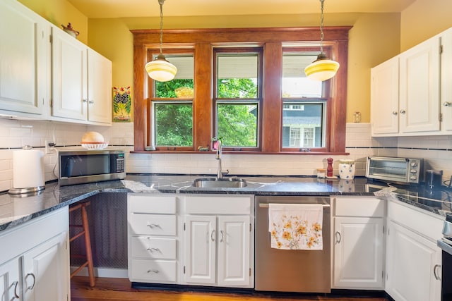 1668 Forest Ave, Memphis, TN 38112 - kitchen featuring appliances with stainless steel finishes, healthy amount of natural light, white cabinets, and tasteful backsplash