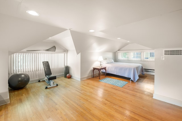 1668 Forest Ave, Memphis, TN 38112 - bedroom with light wood-style floors, vaulted ceiling, recessed lighting, and a baseboard heating unit