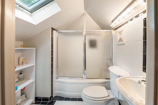 1668 Forest Ave, Memphis, TN 38112 - bathroom with a skylight, vaulted ceiling, tile patterned flooring, and enclosed tub / shower combo