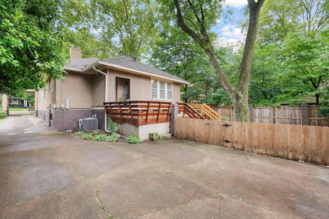 1668 Forest Ave, Memphis, TN 38112 - view of side of property with a chimney, roof with shingles, a deck, and concrete driveway